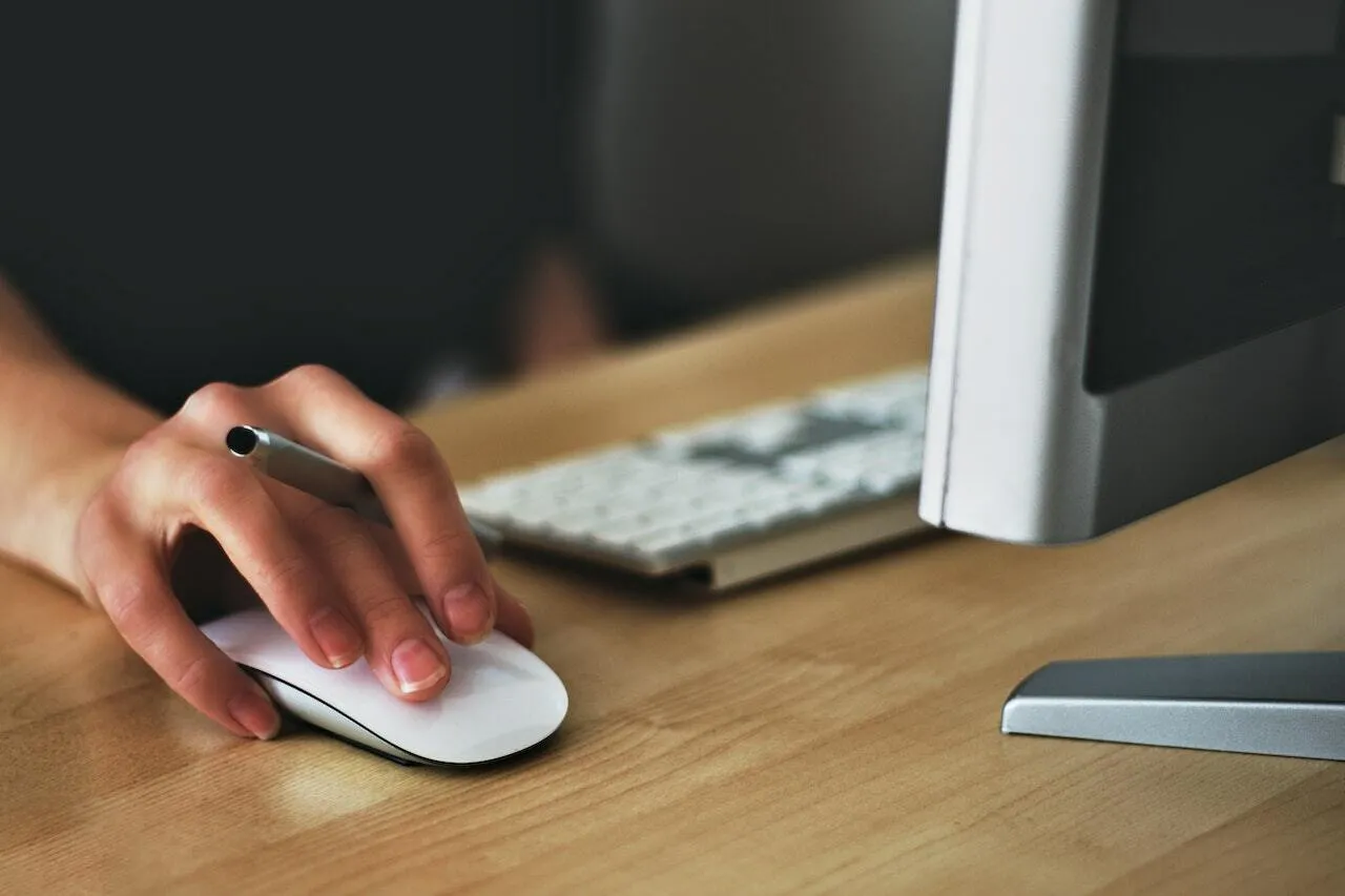 Hand using mouse to work on computer