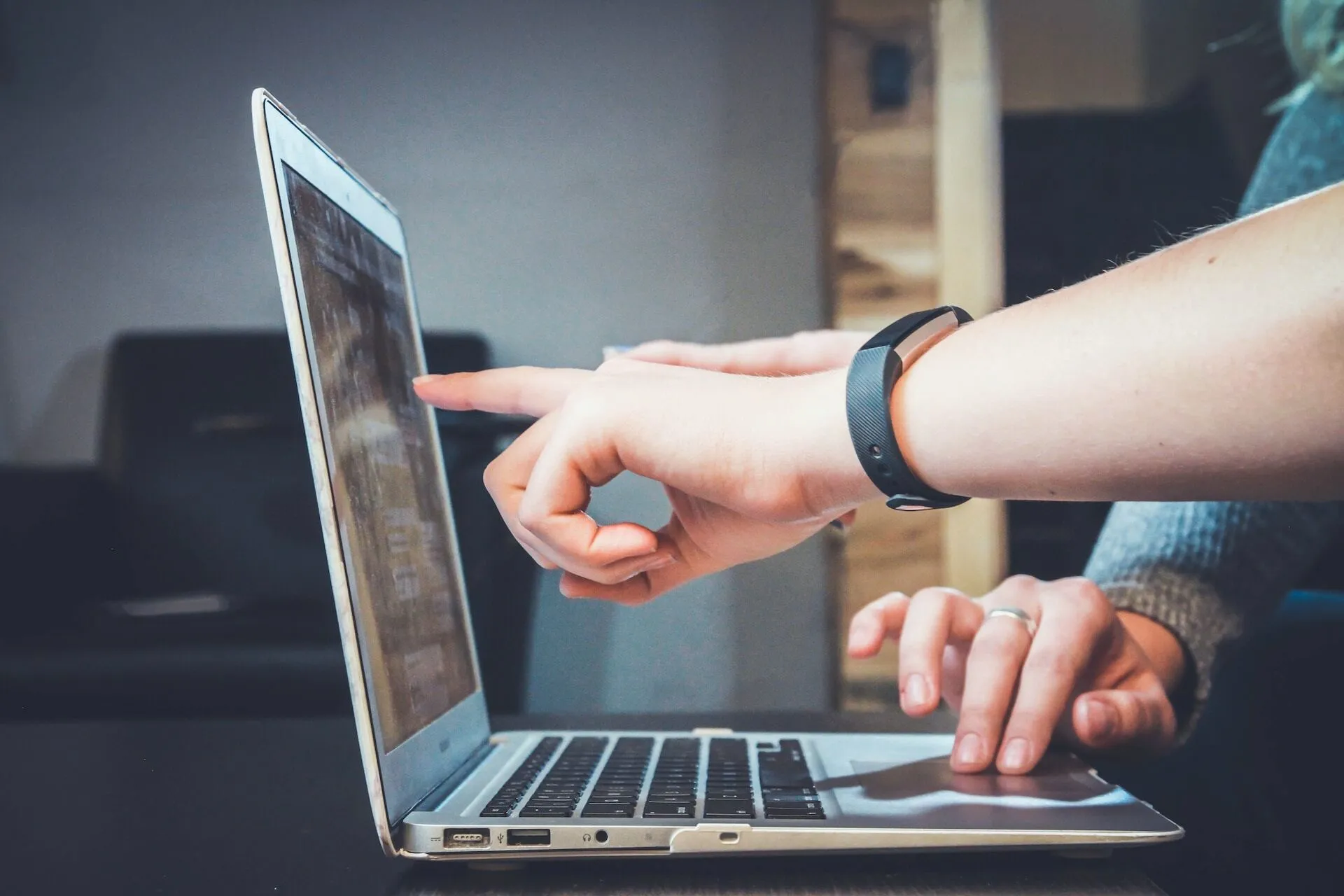 People point at and discuss analytics on a computer