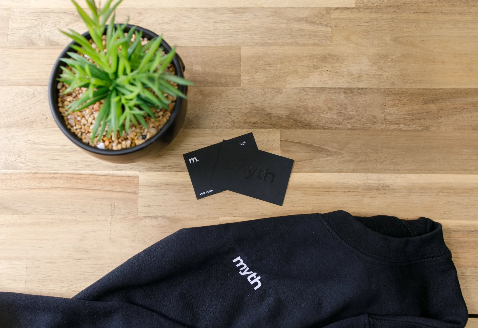 Myth branded sweatshirt and cards on a desk
