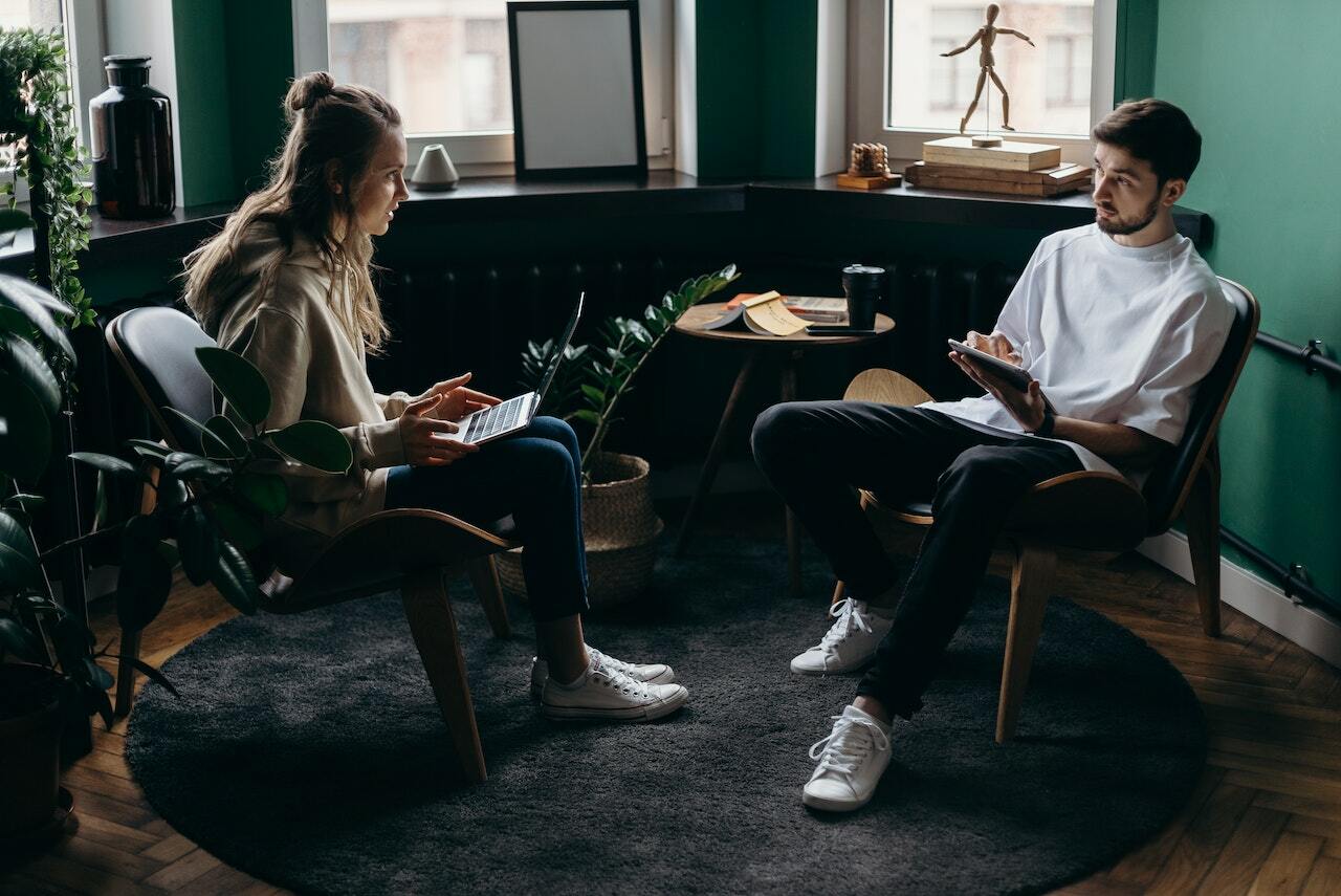 Man and woman using tablets and discussing