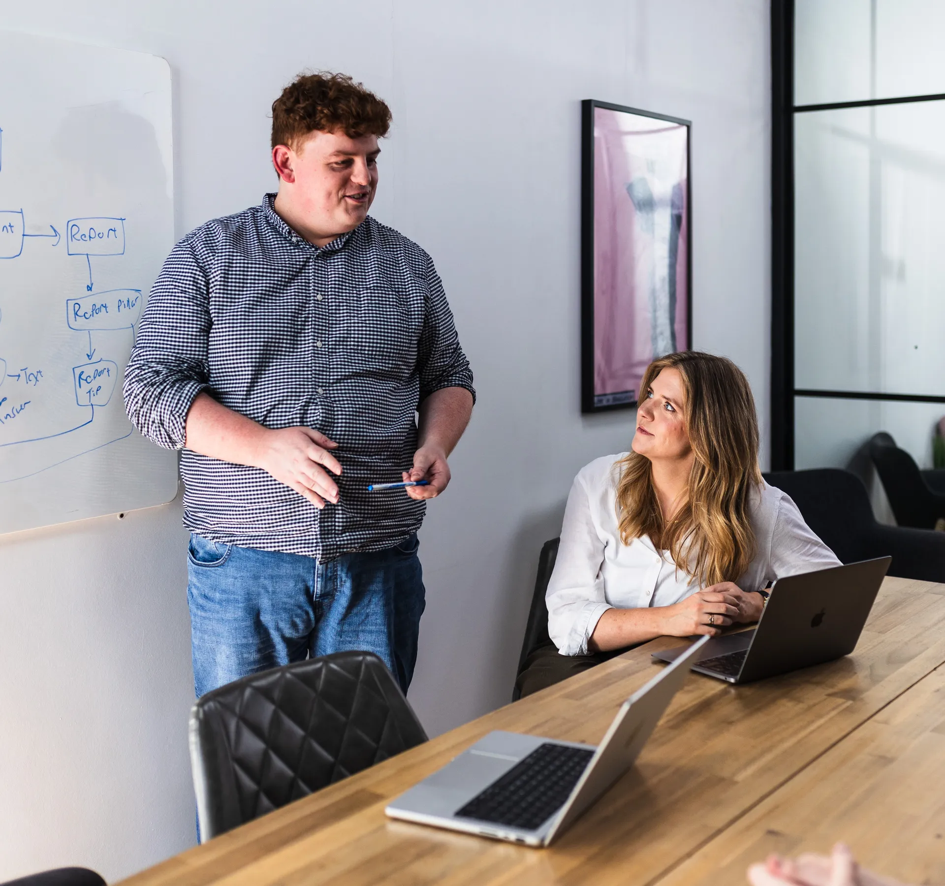 Team member standing at a whiteboard addressing the room