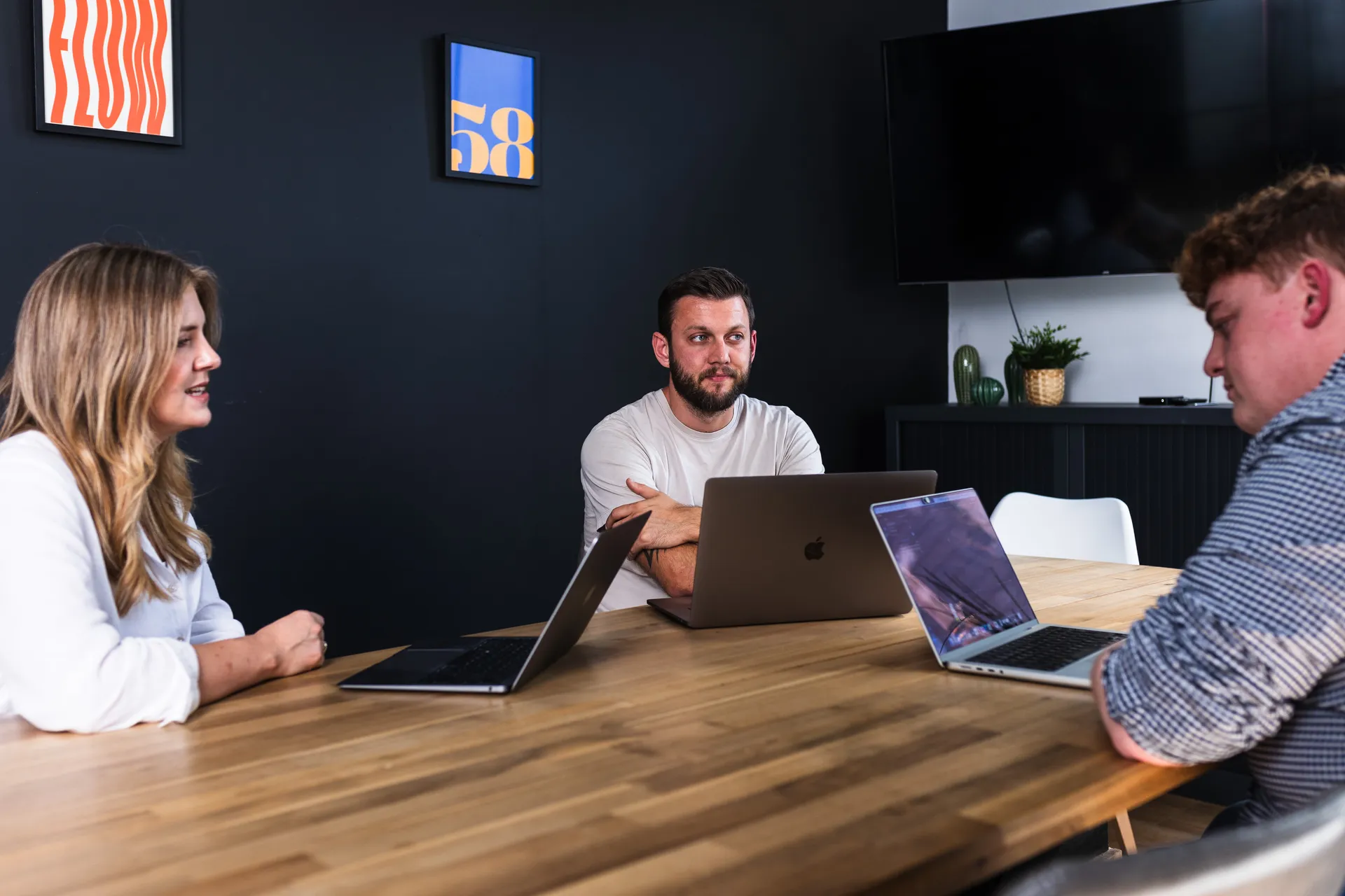 Client meeting round the table with laptops, framed 58 print