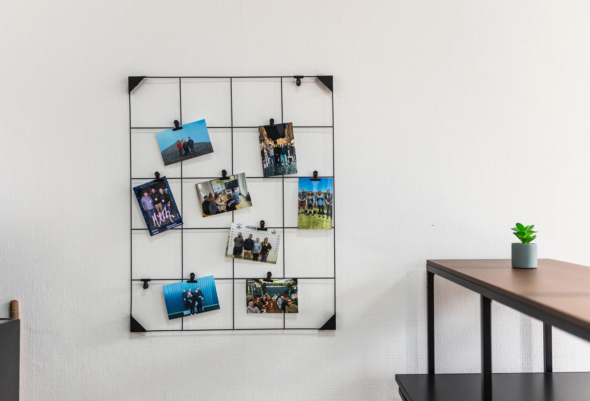 Photo grid of team pictures on a wall